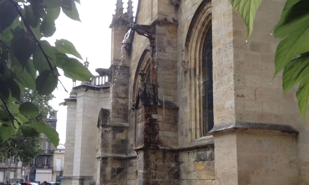 Gargoyle releasing rainwater away from a Gothic stone building